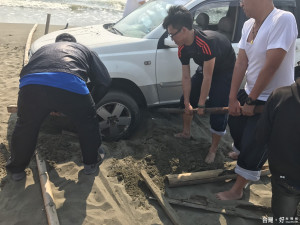 海巡署五一大隊主動協助釣客車輛陷沙灘脫困情形。（記者邱仁武／攝）