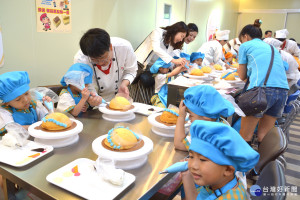 台南佳里區彼緹娃藝術蛋糕工廠老闆洪佳寶(左三)親自教學童做蛋糕。(圖/記者黃芳祿攝)