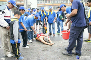 府城「武聖宮」鯉魚神落駕附身在乩童，乩童用游泳方式回到慶安宮母廟主神千歲爺身邊謁祖，沿路信眾提著水桶灑水為鯉魚神「開水路」。(圖/台南西港慶安宮提供)