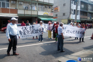 學甲民眾持「抗議殺人兇手電磁波」白布條走上街頭。左一為臺南市議員謝財旺。(圖/記者黃芳祿攝)