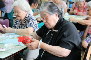 圖片說明1：長輩拿著中藥驅蚊包好奇的研究、試聞