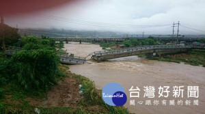 新北市金山區北22線磺溪橋，因抵擋不了大雨帶來的大水沖刷，約在下午1時許被大水沖斷，所幸當時並無人車經過。警方目前已在現場拉起封鎖線，限制通行。（圖／警方提供）