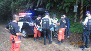 圖:大溪警分局霞雲派出所員警及消防隊員將陳姓巡山員救出後，將他送醫治療。(記者陳寶印攝)

