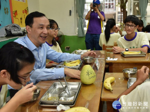 市長朱立倫到市立板橋國中與學生共享營養午餐話家常，也向同學提問有機蔬菜的好處。（圖／記者黃村杉攝）