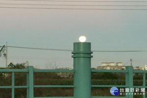 超級月亮清晨落下時的身影也很美，它落在台南一所國中欄杆上，像似暗夜農家屋台外點亮的夜燈。(圖/記者黃芳祿攝)