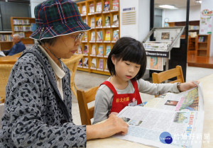 年僅9歲的華湘儀小朋友，不管是整理書籍，或者將書放到書架上，更會讀報紙給阿公阿嬤聽。（圖／記者黃村杉攝）