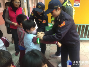 女警協助學童綁上反光條。