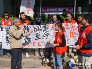 新屋大火殉職警消家屬及「消防員工作權益促進會」人員在桃園市政府前陳情，消防局副局長龍榮森代表消防局出面回應。