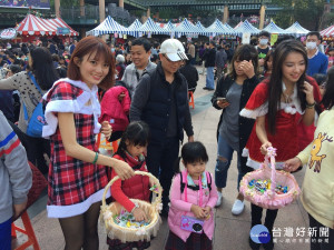 市府同仁裝扮的聖誕老公公、耶誕女郎，在現場發送糖果餅乾，分享歡樂。（圖／記者黃村杉攝）