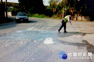 下寮村大馬路上遭不明物體佔據道路，客厝所警員張子袁趕緊將豆腐渣清除乾淨，避免可能造成更多的交通阻礙。（記者陳昭宗拍攝）