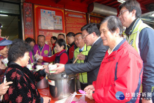 彰化市長邱建富在大東門福德祠舀麻油雞酒給信眾食用。圖／記者鄧富珍攝