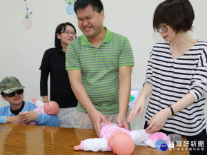 視障者透過實務操作學習如何照顧嬰兒，職能治療師顏維貞指導視障者如何照顧嬰兒。（圖／記者黃村杉攝）