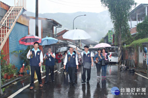 縣長等人冒雨走訪十三間老街。（記者許素蘭／攝）