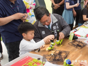 桃園市長鄭文燦於「奔跑吧！四合一戰士」活動中，與小朋友合組機器人。