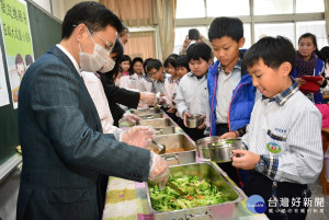 綠能午餐計畫說明會後，縣長魏明谷為學童們打菜。