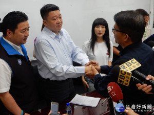 邱敬斌20日出席新北市議會第三審查會說明釐清，並因情緒失控摔紙張90度鞠躬向何博文議員道歉握手致意。（圖／記者黃村杉攝）