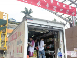 市圖中和分館將行動圖書車開進永平高中考場駐點，提供現場借書及辦證服務，同時還有扇子、礦泉水等消暑關懷。（圖／市圖提供）