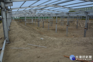 種電業者抽掉漁塭水，在漁池上方搭建好準備搭蓋太陽能板骨架。(圖/記者黃芳祿攝) 