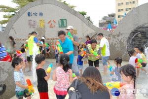 彰化市長邱建富在兒童公園的親水區和小朋友打水仗。