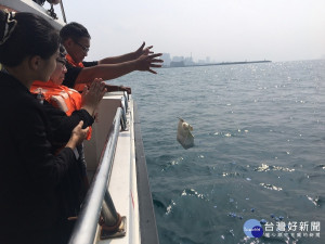 107年最後一場海葬21日在八里渡船頭舉行，18個家庭將親人骨灰連同鮮花灑向大海，回歸大自然的懷抱 。（圖／殯葬處提供）