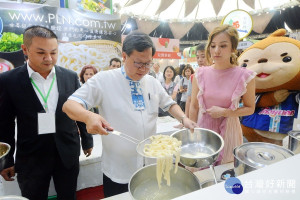 「107年桃園食安嘉年華」活動中，桃園市長鄭文燦於展售攤位上體驗煮麵。