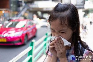 portrait of cute little girl blowing nose in paper handkerchief,Asian girl sneezing in a tissue in the city street concept of pollution,dust allergies