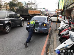 警員在後方使力推車，單憑一人之力無法完成。