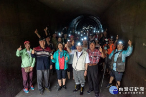 桃園農田水利會長黃金春在「桃園大圳隧道健行」中，與參加活動的民眾在隧道出口合影。