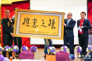 「洪門108將金平之友會」成立大會中，全世界洪門團結聯盟總會長鄭守博代表父親將手書的「惟惠之懷」墨寶贈送給王金平。