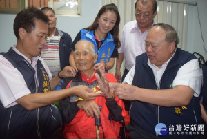 

台中市副市長陳子敬二十七日執行99重陽節敬老活動，代送各階政府禮物、禮金給大甲百歲人瑞張在額，並與大甲區長顏金源為人瑞掛上金鎖片，場面十分溫馨。（記者陳榮昌攝）
