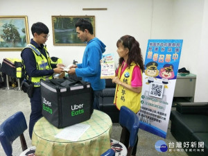 中壢派出所員警遞上扣環式LED閃光警示燈及濕紙巾，期盼他騎車工作時能注意行車安全。（圖／中壢分局提供）