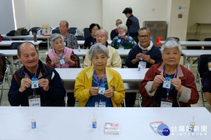 康年學苑失智長者開心的為「防走失神器」穿上新衣。
