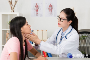 young beauty female doctor touching patient neck to check tonsils status during flu time.