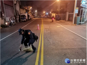 警員在馬路上用磁鐵撿螺絲。林重鎣翻攝