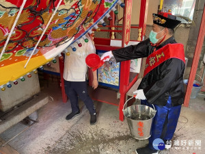 王船出澳儀式將水潑灑船身四周，象徵水到舟行。
