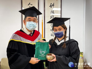 華梵大學校長李天任（左）致贈畢業生代表茶碗
