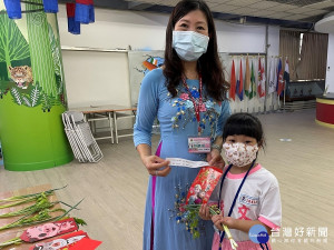 文德國小越南語黃美滿老師用紅細繩綁著芹菜和青蔥給學生，當成開學的見面禮