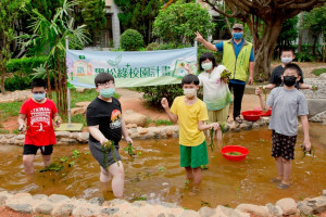 霄裡國小師生體驗校園埤塘的水生植物種植，(右三)為台灣濕地復育協會吳聲譽老師，(右四)為霄裡國小古艷麗校長。