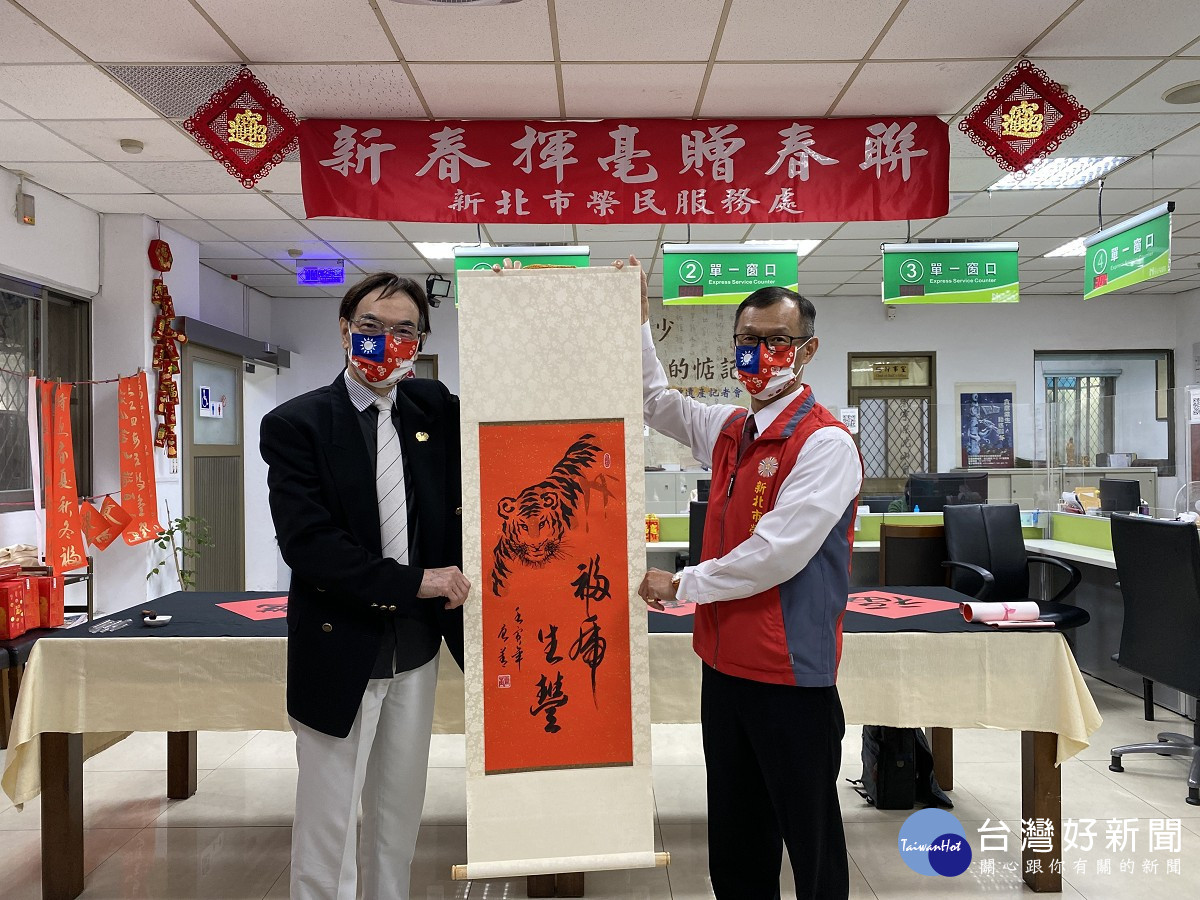 唐菁老師(左)致贈新北市榮服處「福虎生豐」中堂乙幅，由周興國處長代表受贈