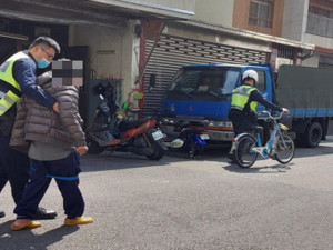 一人扶一人牽車送老人回家。林重鎣