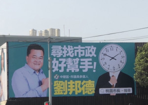 民進黨桃園市議員擬參選人劉邦德的「時鐘人」、「桃園市長–搜尋」看板，引發地方上不少討論。（圖／Tony Chen攝）