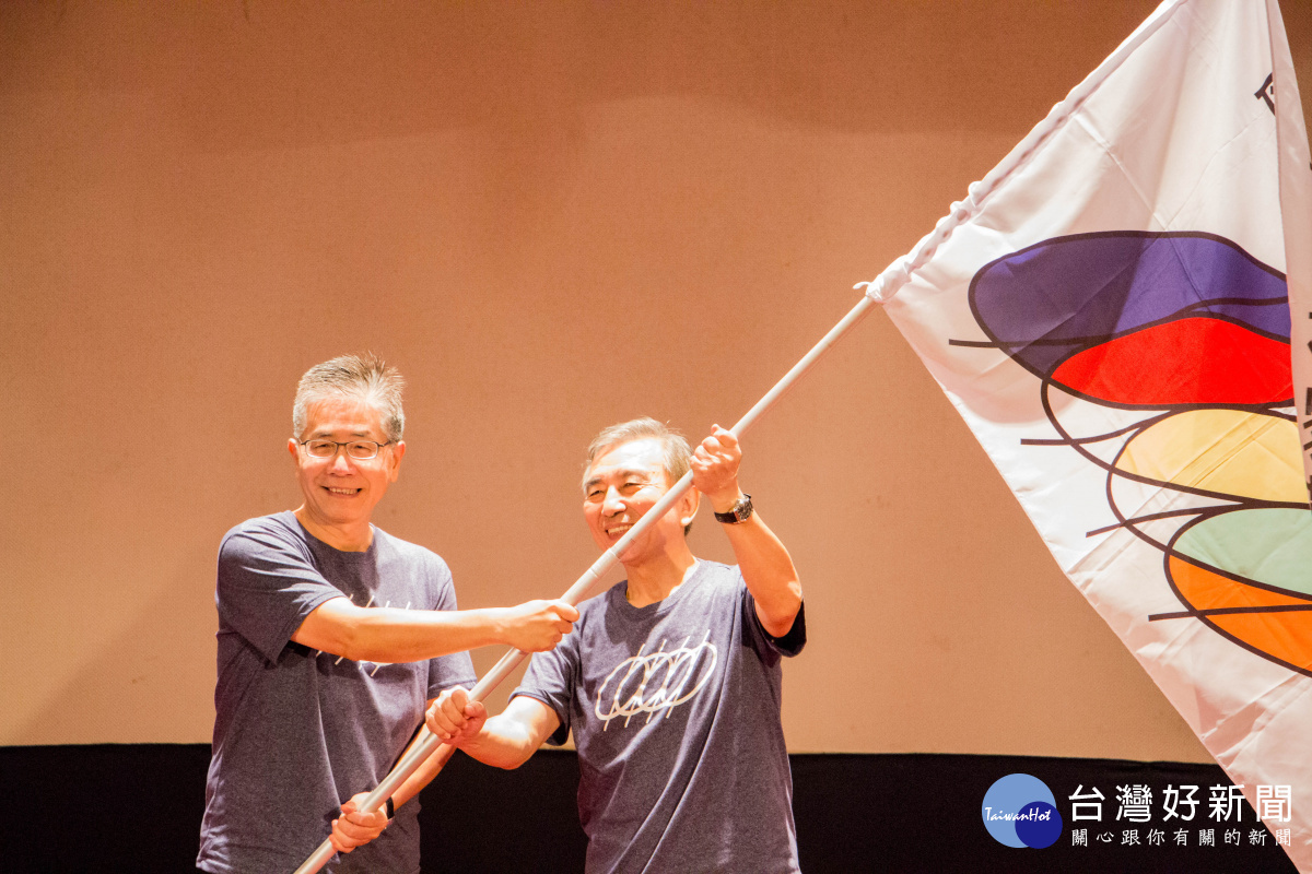 中央大學周景揚校長（左）交接會旗給下一屆主辦學校中央警察大學刁建生校長（右）。