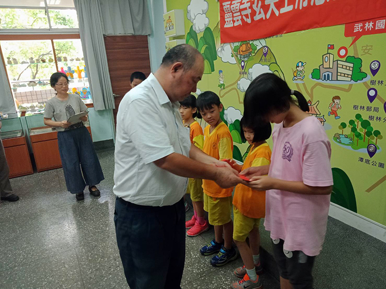 「靈雲寺玄天上帝慈善功德會」善行首航，住持蕭財元為清寒學童頒贈助學金學。（圖╱記者范文濱攝）