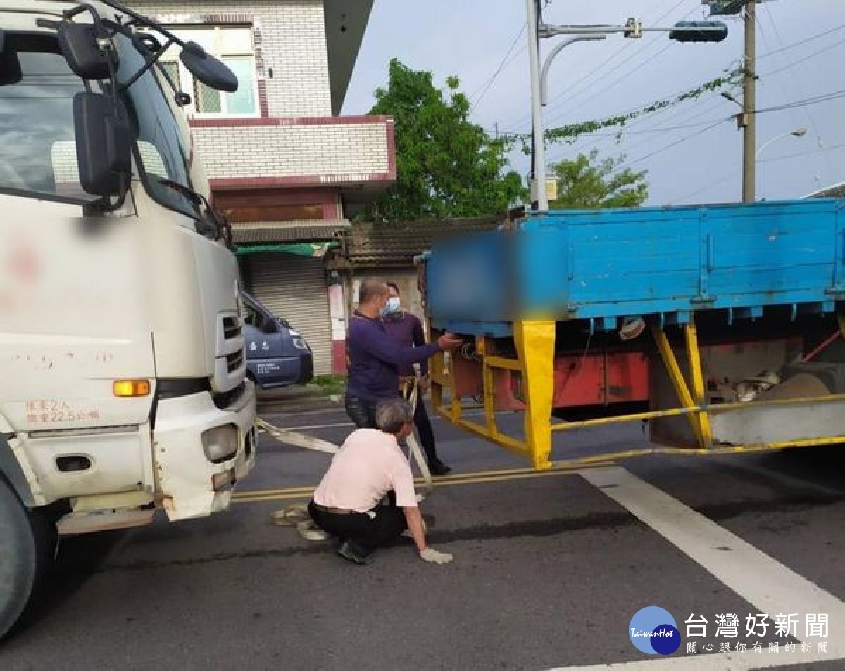 水泥預拌車停等紅燈忽然故障，卡在車道動彈不得，崙豐所巡警發現立即交管警戒，幸好一輛吊車路過伸援，警民合力協助解圍。